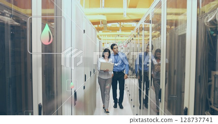 Walking IT staff inspecting server cabinets in data center aisle, with laptop and network cables Walking IT staff inspecting server cabinets in data center aisle, with laptop and network cables 128737741