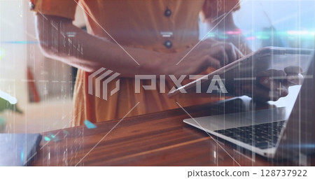 Image of data processing against mid section of woman using laptop and digital tablet 128737922