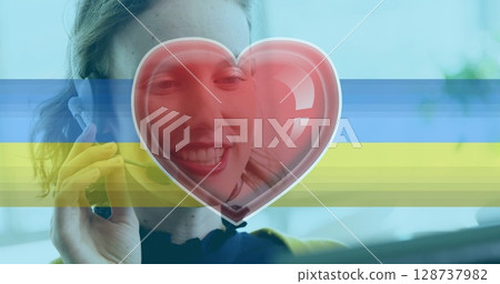 Image of heart icon and flag of ukraine with caucasian businesswoman using phone headset 128737982