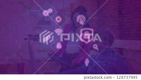 Discussing cybersecurity on tablet by Asian woman in blazer and man at office, security icons 128737995