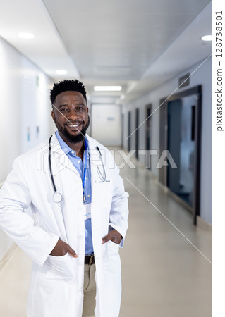 African American doctor standing in hospital corridor, wearing lab coat with stethoscope, ID badge African American doctor standing in hospital corridor, wearing lab coat with stethoscope, ID badge 128738501