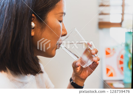Woman drinking fresh cold water from glass. 128739476