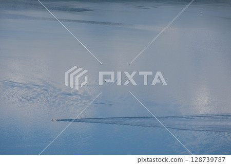 A boat creating ripples on the lake A boat creating ripples on the lake 128739787