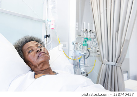 Senior African American woman resting in hospital room, with IV and ventilator tubing, copy space Senior African American woman resting in hospital room, with IV and ventilator tubing, copy space 128740437