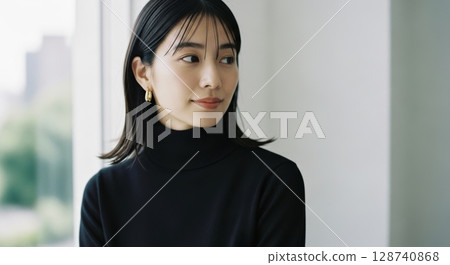 窗邊一位穿著黑色高領毛衣的女子的肖像照片 128740868