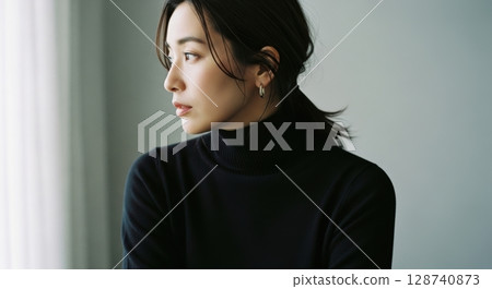 窗邊一位穿著黑色高領毛衣的女子的肖像照片 128740873