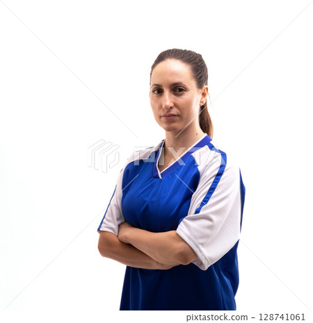 Woman standing in studio setting with arms folded, wearing blue and white athletic jersey 128741061