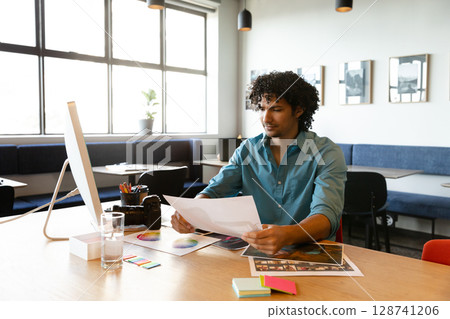 Man reviewing photos and color swatches alongside DSLR camera on creative studio table, copy space Man reviewing photos and color swatches alongside DSLR camera on creative studio table, copy space 128741206