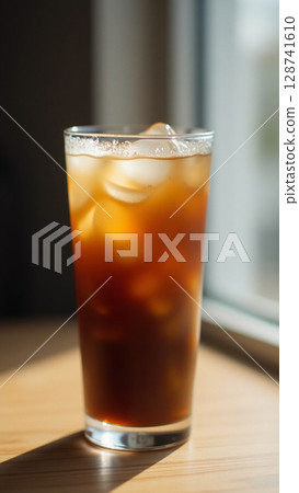 Minimalist Iced Coffee in Sunlit Glass with Melting Ice and Subtle Condensation Detail Minimalist Iced Coffee in Sunlit Glass with Melting Ice and Subtle Condensation Detail 128741610