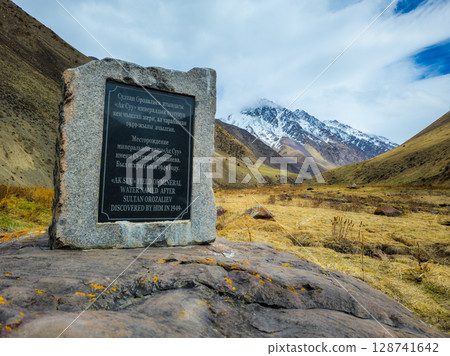 Stone monument Ak-Suu mineral water source at spring day. Stone monument Ak-Suu mineral water source at spring day. 128741642