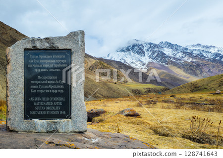 Stone monument Ak-Suu mineral water source at spring day. Stone monument Ak-Suu mineral water source at spring day. 128741643