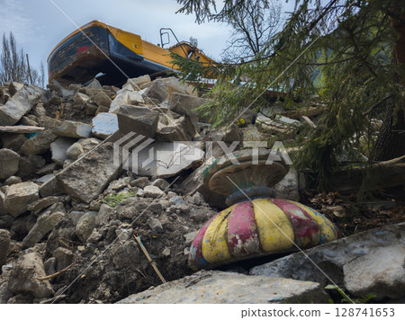 excavator demolishes old soviet architecture with old planter on the ground 128741653