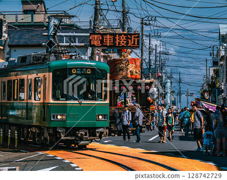 Enoshima Electric Railway 1500-type train passing in front of the festival floats and stalls at Koyurugi Shrine in Koshigoe, Kamakura City, Kanagawa Prefecture 128742729