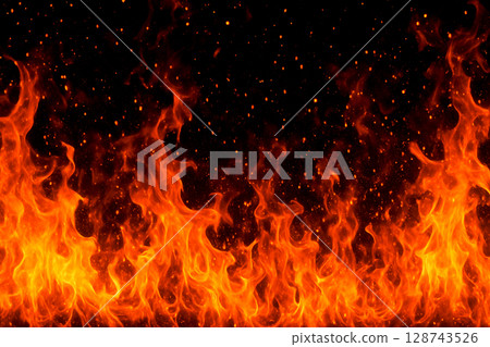 燃燒的火焰散開火花的背景材料。黑色背景上燃燒的真實火焰。火焰的充滿活力的運動和爆炸的火花 128743526