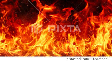 燃燒的火焰散開火花的背景材料。黑色背景上燃燒的真實火焰。火焰的充滿活力的運動和爆炸的火花 燃燒的火焰散開火花的背景材料。黑色背景上燃燒的真實火焰。火焰的充滿活力的運動和爆炸的火花 128743530