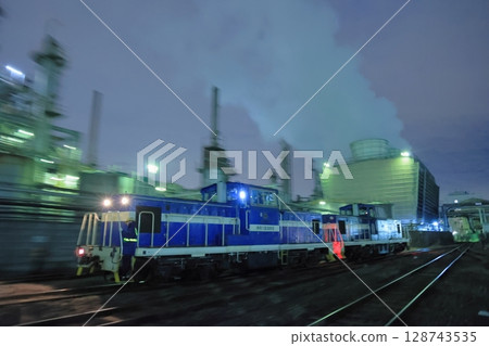 一輛柴油機車穿梭在燈火通明的工廠裡 一輛柴油機車穿梭在燈火通明的工廠裡 128743535