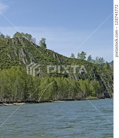 Picturesque mountain river landscape with lush vegetation and clear blue sky above scenery Picturesque mountain river landscape with lush vegetation and clear blue sky above scenery 128743772