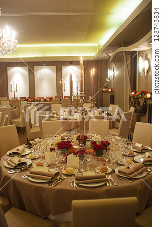 Elegant Banquet Hall With Decorative Table Settings and Mood Lighting Elegant Banquet Hall With Decorative Table Settings and Mood Lighting 128743834
