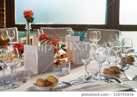 Elegant Dining Table Setting With Roses and Glassware in Soft Natural Light 128743836