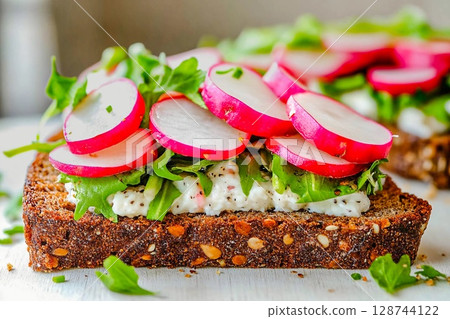 Fresh radish and arugula open sandwich served on dark rye bread during a sunny brunch gathering Fresh radish and arugula open sandwich served on dark rye bread during a sunny brunch gathering 128744122