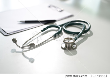 Stethoscope on a white desk with clipboard symbolizing diagnostics, and healthcare concept 128744381