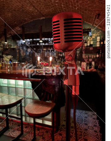 Bar and restaurant performance concept. Microphone on blurred background of bar counter in subdued lighting. 128745421
