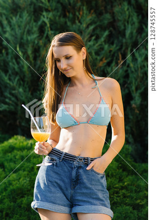 Woman Holding Orange Drink Outdoors 128745557
