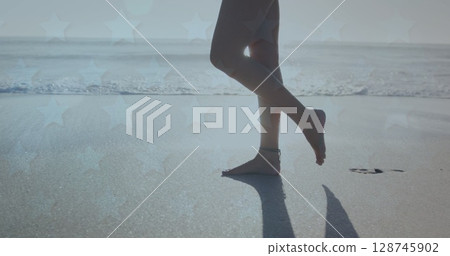 Low section of woman walking on the beach 128745902