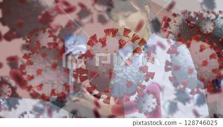 Image of covid cells over male doctor in face mask Image of covid cells over male doctor in face mask 128746025