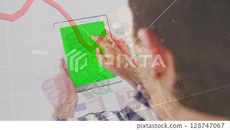 Red graph and sparks of light over caucasian man using digital tablet with copy space 128747067