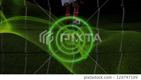 Image of spiral light trail against mid section of male soccer player taking a penalty kick 128747109