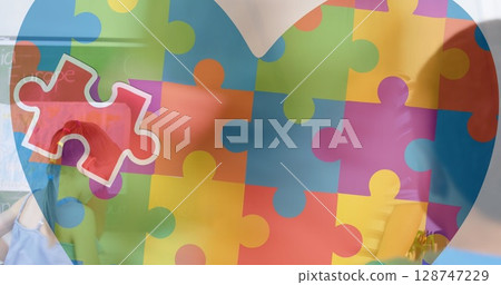 Image of heart made of colorful puzzle over caucasian woman and diverse children playing 128747229