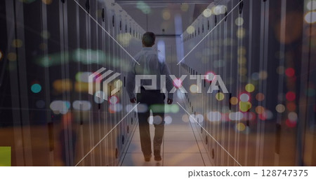 Walking IT technician wearing shirt navigating data center aisle with LED lights on server racks Walking IT technician wearing shirt navigating data center aisle with LED lights on server racks 128747375