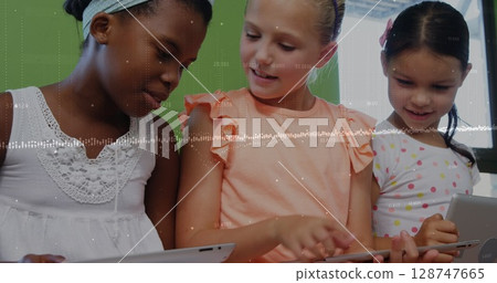 Image of graphs and financial data over diverse girls using tablet in classroom 128747665