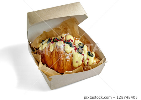 appetizing croissant with blueberries in a cardboard box isolated on a white background 128748403