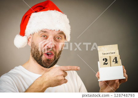December 24th. Man santa hat holds calender 128748793