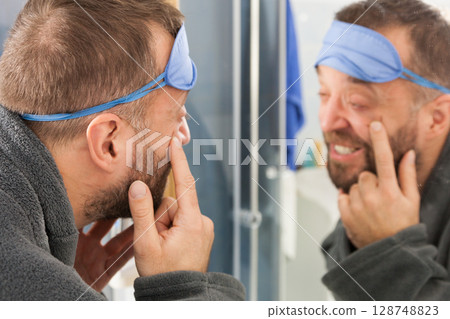Sleepy man looking at mirror Sleepy man looking at mirror 128748823