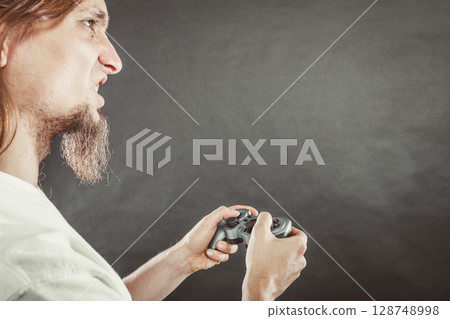 Stressed man playing on pad Stressed man playing on pad 128748998