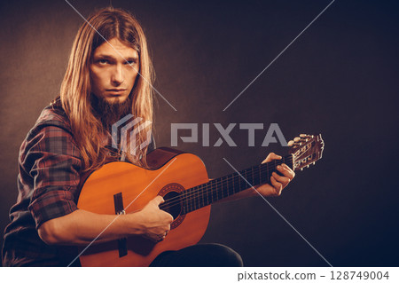 Guitarist trying out chords. 128749004