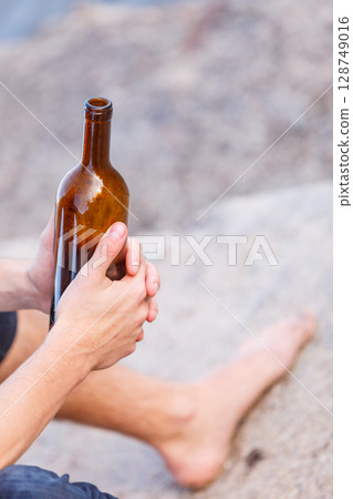 Male hand with wine bottle outdoor 128749016