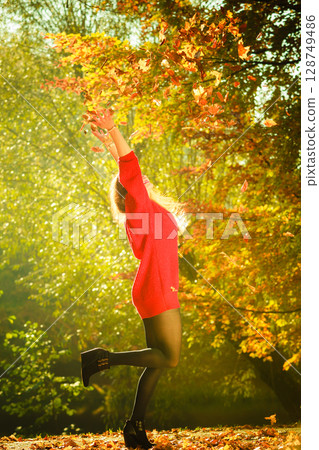 Lady playing with leaves. Lady playing with leaves. 128749486