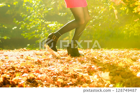 Playful woman outdoors playing with leaves. Playful woman outdoors playing with leaves. 128749487