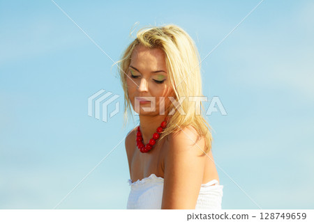 Beautiful woman wearing white dress, sky background Beautiful woman wearing white dress, sky background 128749659