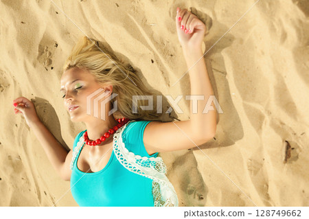 Beautiful blonde girl on sandy beach, portrait Beautiful blonde girl on sandy beach, portrait 128749662