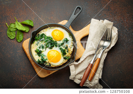 Healthy spinach omelette in cast iron pan top view 128750108
