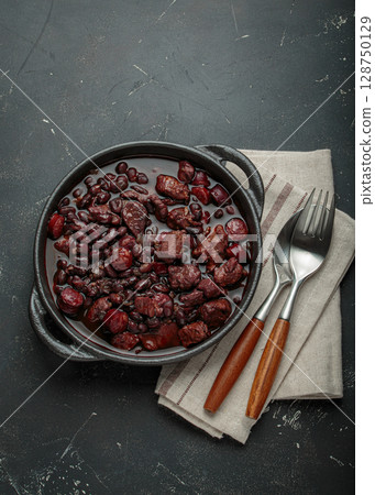 Brazilian feijoada with black beans, sausage and meat in a pot, top view Brazilian feijoada with black beans, sausage and meat in a pot, top view 128750129