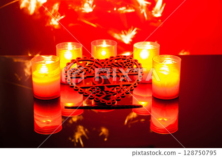 On a colorful background, small candles flicker brightly 128750795