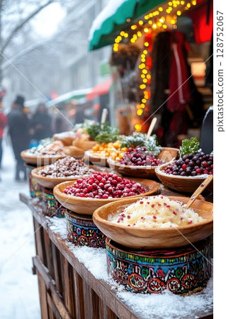 Winter market stall displays colorful bowls of berries and sweet treats, dusted with snow 128752067