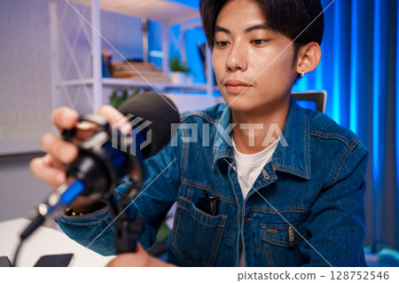 Young man adjusting microphone for podcast recording in home studio 128752546