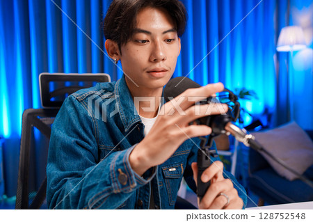 Young man adjusting microphone for podcast recording in home studio 128752548